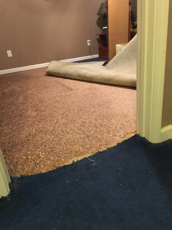 Carpet pad removal revealing water damage during Water Mitigation Services in Rawlins